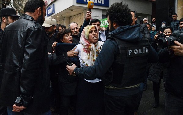 Turkish policeman and protesters clash during a demonstration against government-imposed curfews